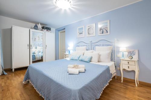 a blue and white bedroom with a bed and a table at Villa Daisy in Quartu SantʼElena