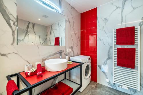 a bathroom with a sink and a washing machine at Apartment il cuore rosso in Naturno