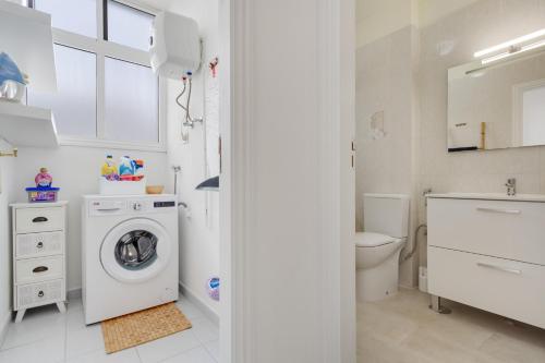 a white bathroom with a washing machine in it at Medano House in El Médano