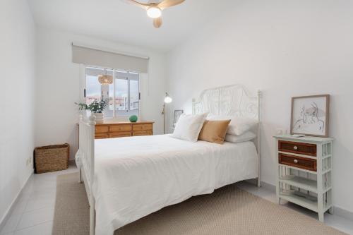a white bedroom with a white bed and a dresser at Medano House in El Médano