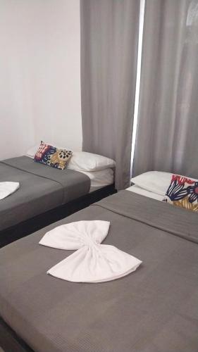 a room with two beds with towels on them at Tolu - Caribbean apartment in Santiago