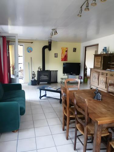 a living room with a table and a couch at Gîte À La Campagne in Bourdeaux