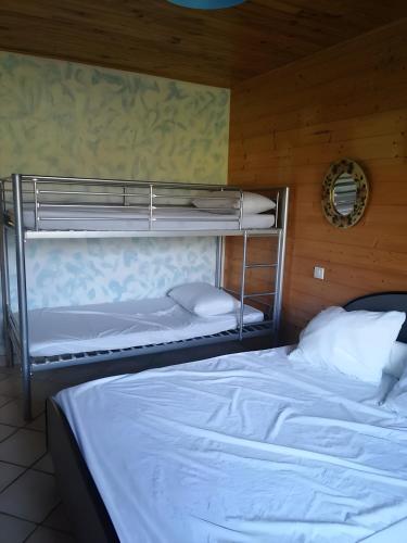 a bedroom with two bunk beds and a mirror at Gîte À La Campagne in Bourdeaux