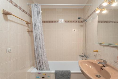a bathroom with a sink and a bath tub and a shower curtain at Casa Mara in Sauzal