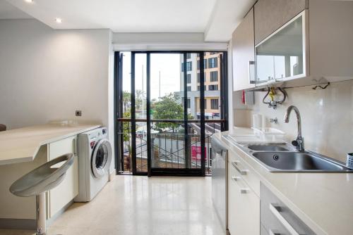 a kitchen with a sink and a washing machine at Apartamento Forum View in Funchal