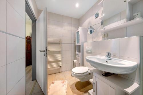 a white bathroom with a sink and a toilet at Apartment Ankerplatz in Bremerhaven