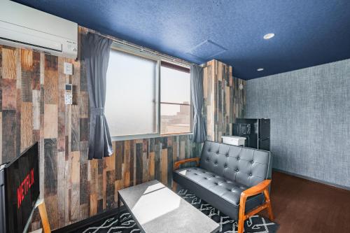 a waiting room with a leather couch and a window at Silk Court 402 in Chitose