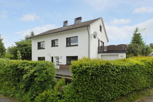 a white house with bushes in front of it at Ferienwohnung Dorlar in Schmallenberg