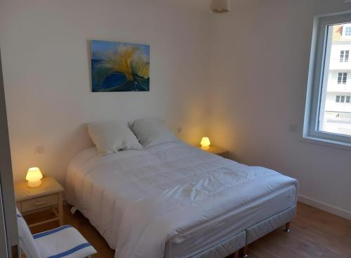 a bedroom with a bed and a painting on the wall at Résidence Oscar Wilde entrée A in Neufchâtel-Hardelot