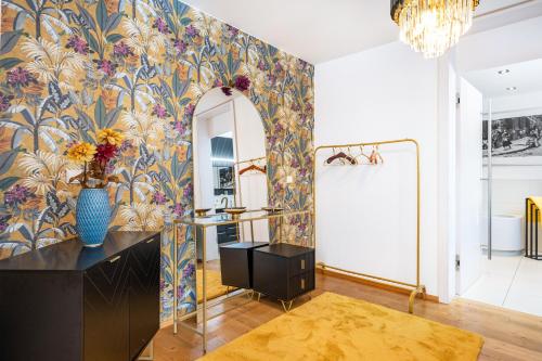 a bathroom with a mirror and a vase of flowers on a wall at Apartment Himmelweit in Freyung