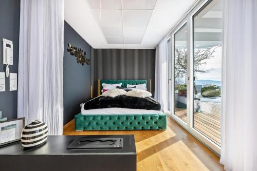 a bedroom with a green bed and a balcony at Apartment Himmelweit in Freyung