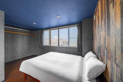 a bedroom with a white bed and a window at Silk Court 402 in Chitose