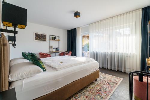 a bedroom with a large bed and a window at Flora und Fauna by Kamelu in Gengenbach
