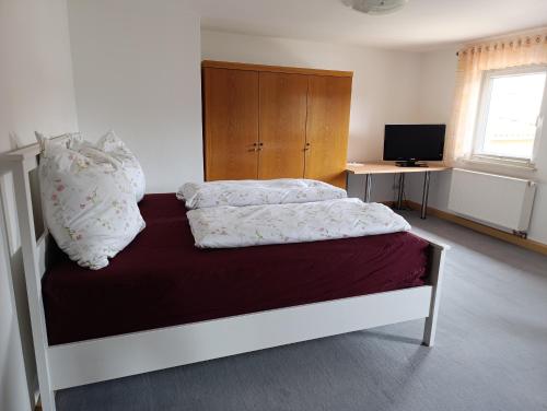 a bedroom with a bed and a desk with a television at Zirbelkiefer 8 in Bad Klosterlausnitz