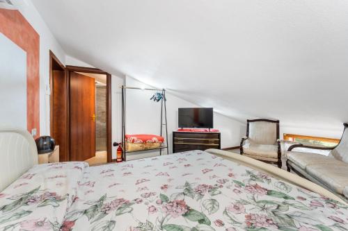 a bedroom with a bed and a couch and a television at Casa Eleonora in San Sperate