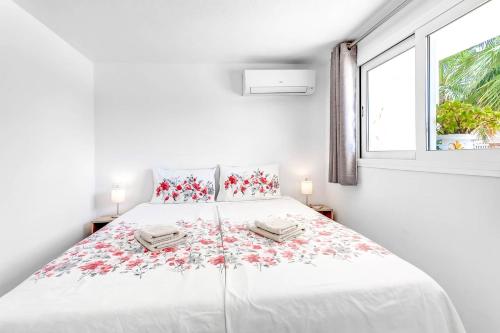 a white bedroom with a large bed with flowers on it at Studio Torreblanca close to beach in Fuengirola