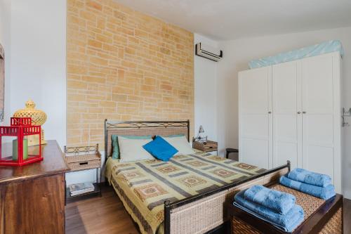 a bedroom with a bed and a brick wall at Casa Roberta in Granitola