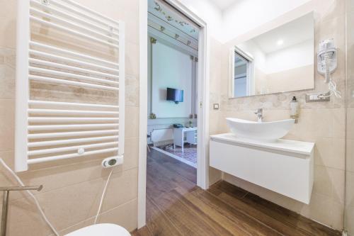 a bathroom with a white sink and a mirror at Epoque in Messina