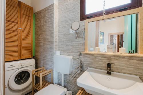 a bathroom with a sink and a washing machine at Casa Roberta in Granitola