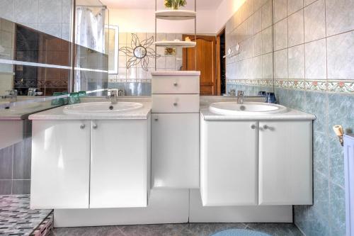 a white bathroom with two sinks and a mirror at Maison de vacances proche de Sarlat in Carsac-Aillac
