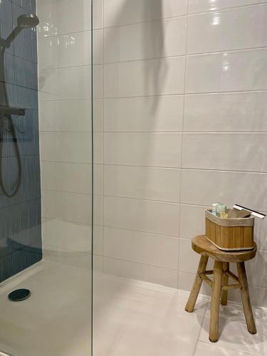 a shower with a wooden stool next to a glass door at Vue Mer Et Jardin in Théoule-sur-Mer