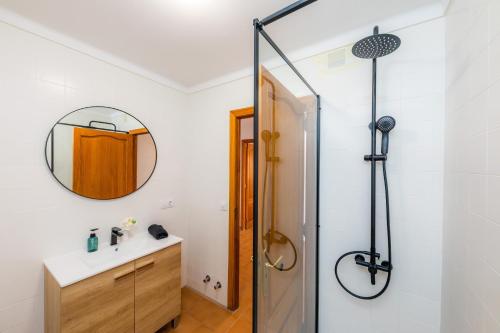 a bathroom with a shower and a sink and a mirror at Es Port in Cala Ratjada