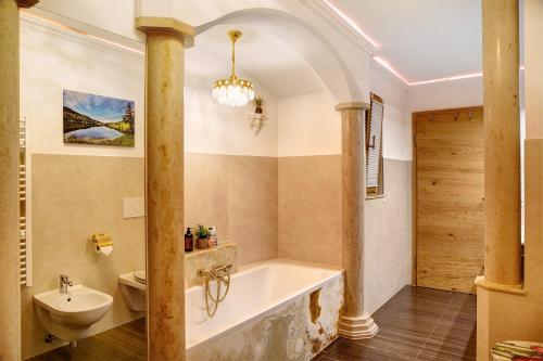 a bathroom with a tub and a toilet and a sink at Ferienwohnung Lapislazuli in Mittenwald