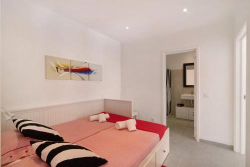 a white bedroom with a large bed with black and white pillows at Large apartment in Vale do Lobo in Almancil
