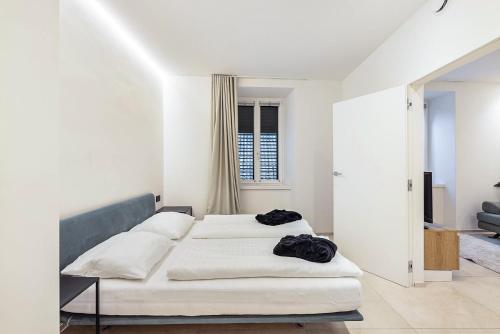 two beds in a white room with a window at App 206 Palazzo Cavour in Bolzano
