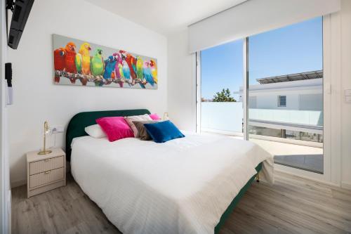 a bedroom with a bed with a painting on the wall at Casa Blanca in Torre del Mar