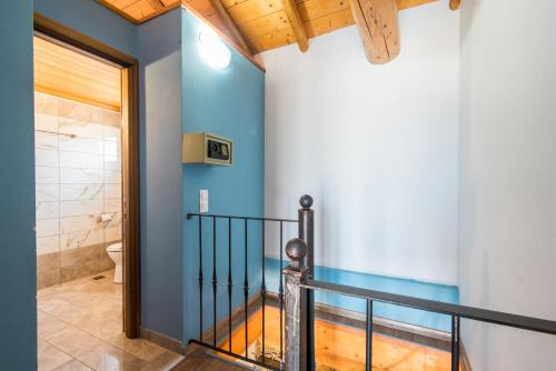 a bathroom with a staircase with a blue wall at Mirage Arillas Maisonette A in Arillas