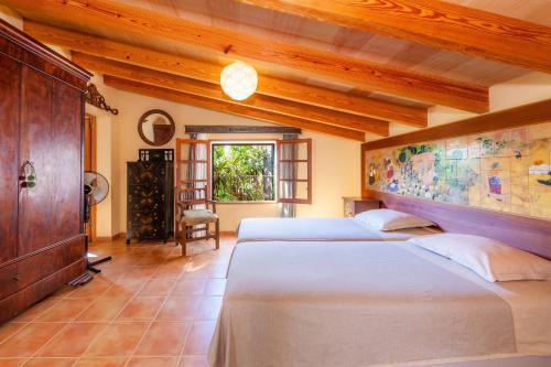two beds in a room with wooden ceilings at Acuario-Géminis in Llucmajor