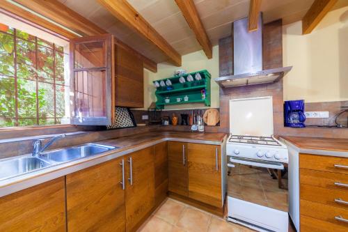 a kitchen with wooden cabinets and a sink and a stove at Acuario-Géminis in Llucmajor