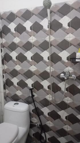 a bathroom with a shower and a toilet at Cozzee AnD in Labuan Bajo