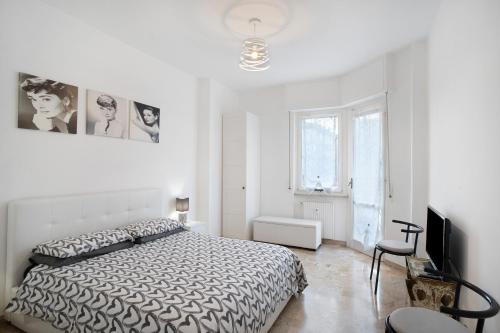 a white bedroom with a bed and a television at Albenga Mary 43 6 in Albenga