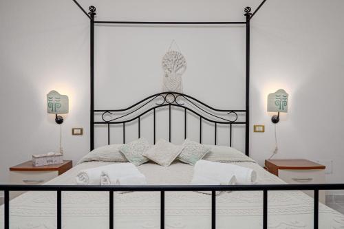 a bedroom with a large black canopy bed with pillows at Casa Elisa in Padru