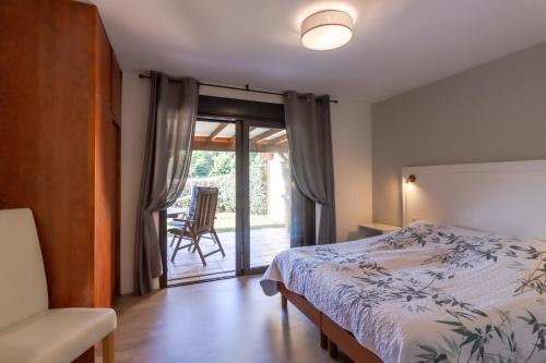 a bedroom with a bed and a sliding glass door at Maison Liz in Castelnaud La Chapelle