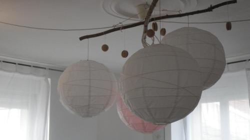 three paper lanterns hanging from a ceiling at La Slow Life in Saint-Maurice-sous-les-Côtes