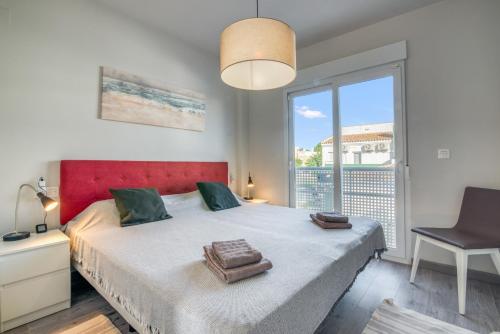 a bedroom with a bed with a red headboard and a window at Casa Isabel in El Verger
