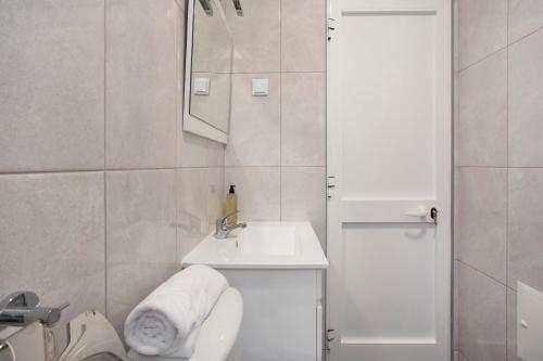 a white bathroom with a sink and a toilet at São Vicente House in São Vicente