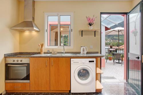 a kitchen with a washing machine and a sink at São Vicente House in São Vicente