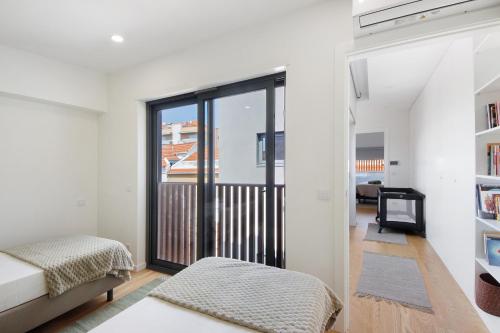 a living room with a bed and a balcony at Flor de Sá in Aveiro