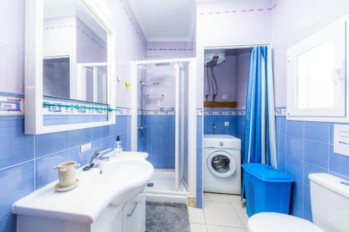 a bathroom with a sink and a washing machine at Es Cantonet in Porto Cristo