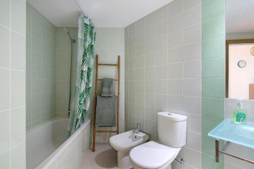 a bathroom with a toilet and a tub and a sink at Vista Mar in Cabanas de Tavira