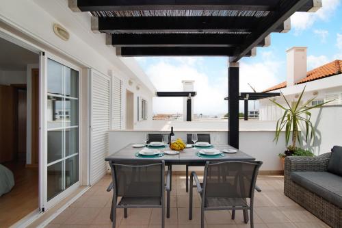 a dining room with a table and chairs on a patio at Vista Mar in Cabanas de Tavira