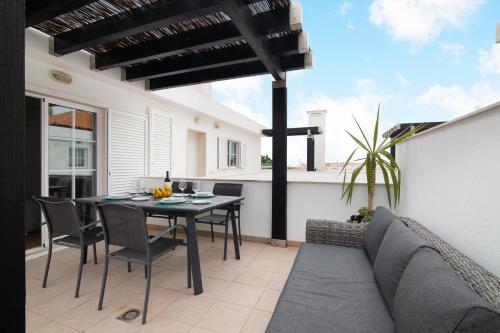 a patio with a table and chairs and a couch at Vista Mar in Cabanas de Tavira