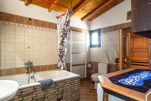 a bathroom with a tub and a toilet and a sink at Villa Koutoupakia in Kefallonia