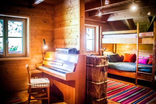 a room with a piano in a log cabin at Ferienwohnung am Hirschenmoor in Breitnau