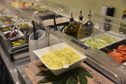 a buffet with a bowl of food on a counter at Arthotel Munich in Munich