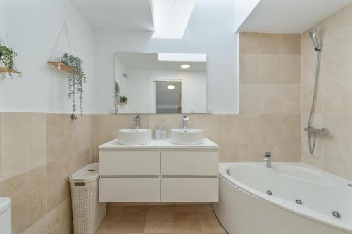 a bathroom with two sinks and a bath tub and a tubermott at Dúplex Bellas Vistas in Ojén